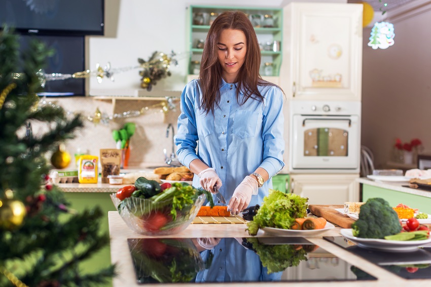 Woman preparing a healthy, festive season dish in the kitchen for better gut microbiome health